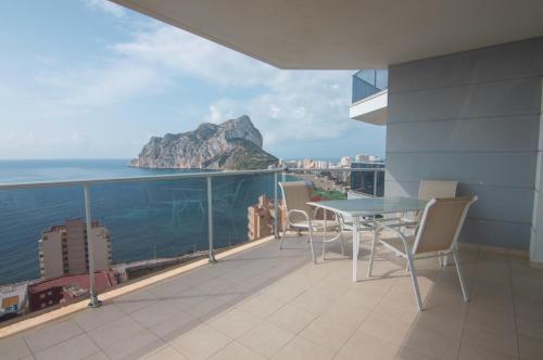 a balcony with a table and chairs overlooking the ocean at Apartamentos Entremares - Grupo Antonio Perles in Calpe