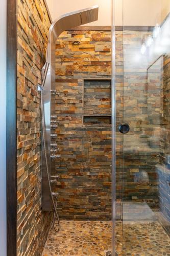a shower in a bathroom with a brick wall at Above and Beyond in Boone