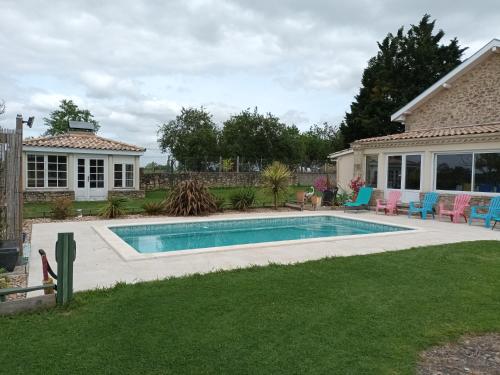 une piscine dans une cour à côté d'une maison dans l'établissement le gite des 4 saisons, à Blasimon