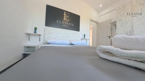 a white bedroom with a large bed with blue pillows at Elysian Luxury Suite N1 in Flogita