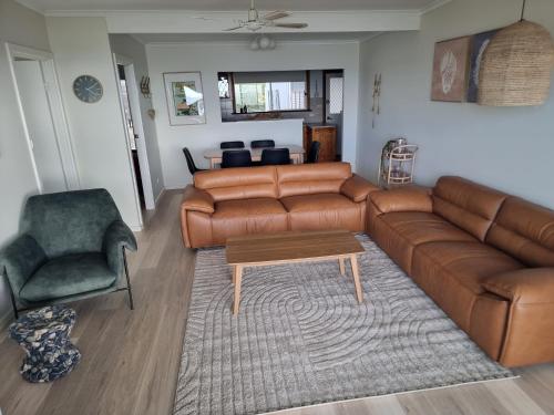 a living room with a brown leather couch and a chair at Mint in Penneshaw