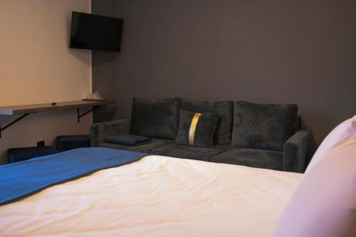a living room with a couch and a bed at Pensiunea Alpin Predeal in Predeal