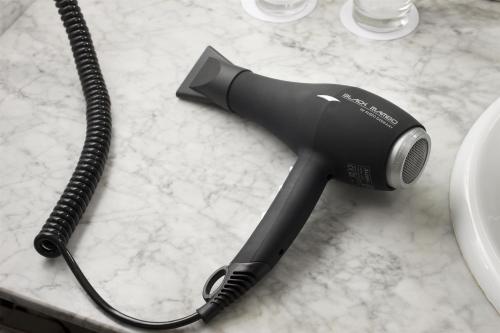 a hair dryer sitting on a counter with a cord at NH Collection Salamanca Palacio de Castellanos in Salamanca
