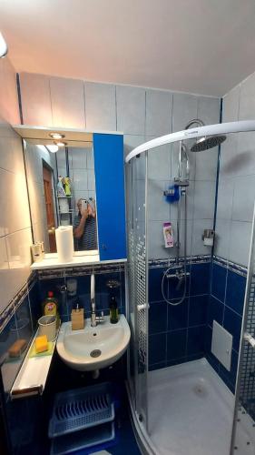 a man taking a picture of a bathroom with a sink and shower at Studio Olimp Black Sea in Olimp