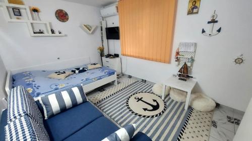 a small room with a blue couch and a bed at Studio Olimp Black Sea in Olimp
