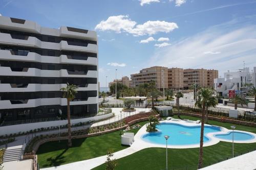 a view of a building and a swimming pool at Lovely modern two bedroom apartment in Arenales del Sol