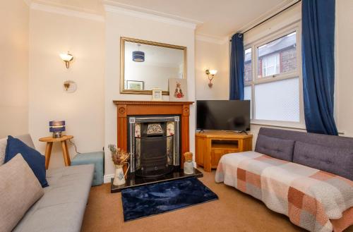 a living room with a couch and a fireplace at Stone's Throw Townhouse in York