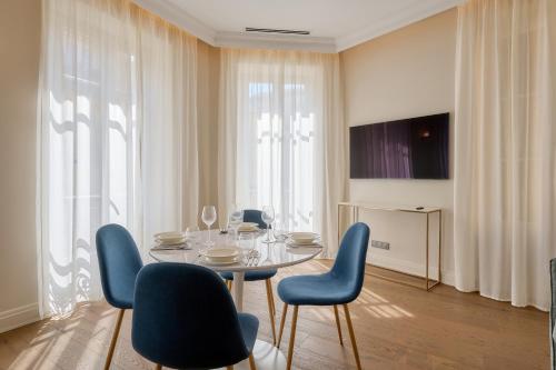 a dining room with a table and blue chairs at Aparthotel 9 ALBERTI Nice Centre in Nice