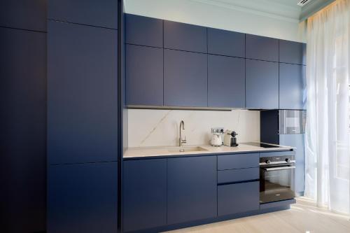 a kitchen with blue cabinets and a sink at Aparthotel 9 ALBERTI Nice Centre in Nice