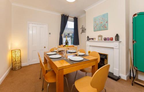 a dining room with a table and chairs and a fireplace at Stone's Throw Townhouse in York