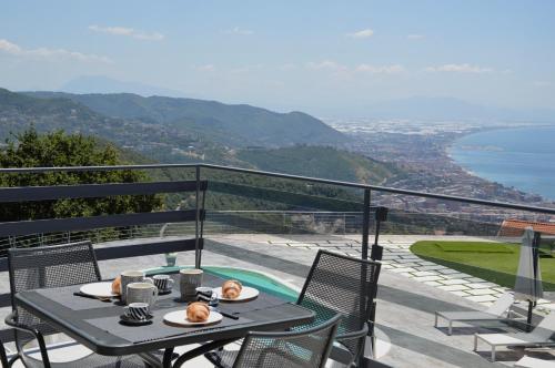 a table on a balcony with a view of the ocean at Tenuta Croce in Salerno