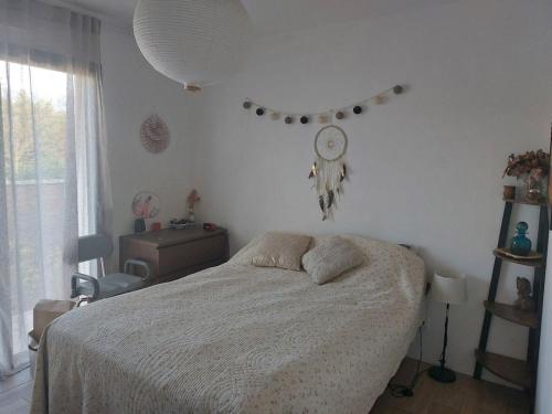 una camera da letto con un letto e un orologio a parete di Villa Cocooning Bassin d'Arcachon a Gujan-Mestras