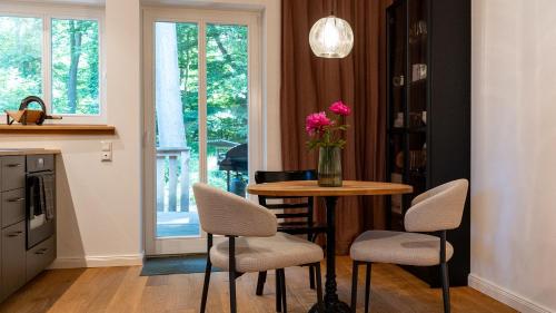 a kitchen with a table with chairs and a vase with flowers at Up de Schüün - Design Studio in Meißendorf