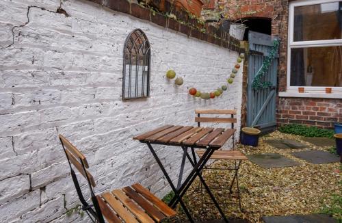 a table and two chairs next to a brick wall at Stone's Throw Townhouse in York