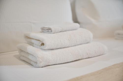 a stack of white towels sitting on a bathroom counter at Aparthotel 9 ALBERTI Nice Centre in Nice