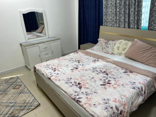 沙迦Al majaz 3 apartment的一间卧室配有一张带梳妆台和镜子的床