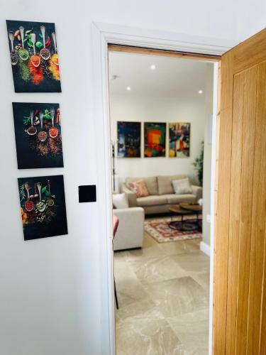 a living room with a couch and a room with paintings at Burton Urban Apartment in Burton upon Trent