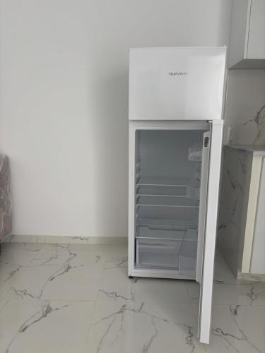 a white refrigerator with its door open in a kitchen at Appartement 1 Yasmine hammamet in Hammamet