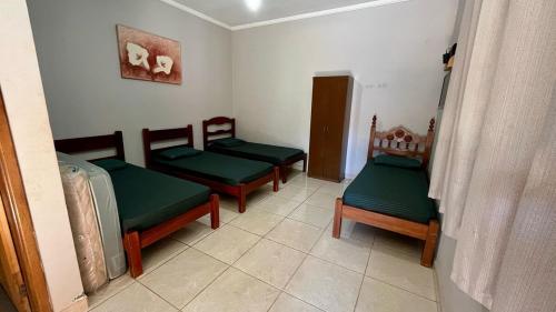 ein Zimmer mit vier grünen gepolsterten Stühlen in einem Zimmer in der Unterkunft Área de Lazer Sertãozinho in Sertãozinho