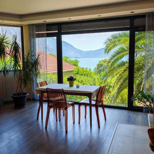 a dining room with a table and chairs and a large window at Meditation in Kotor