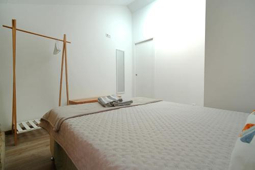 a bedroom with a bed with a phone on it at Preciosa casa en Playa de Razo in Carballo