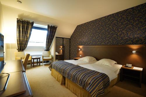 a hotel room with a bed and a desk at Hotel Watermolen Le Mirage in Kasterlee