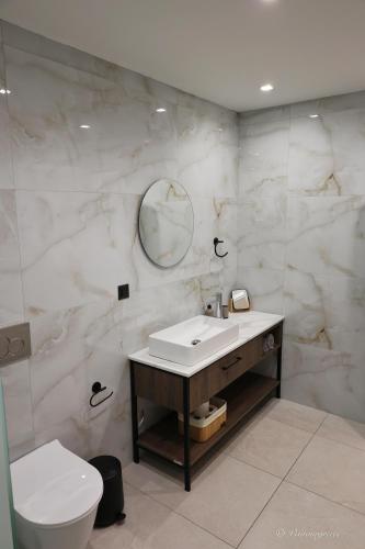 a bathroom with a sink and a toilet and a mirror at Valantina's & Mannouel Lardos Luxury Villas in Lardos