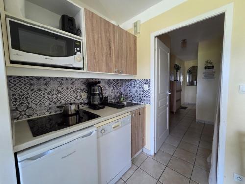 a kitchen with a sink and a microwave at Appartement terrasse, piscines, wi-fi, résidence face mer in Les Sables-dʼOlonne