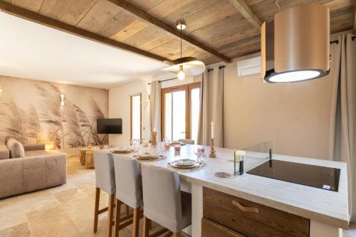 une cuisine et un salon avec une table et des chaises dans l'établissement Mas 9 Romanin - Mas Provençal Familial, à Saint-Rémy-de-Provence
