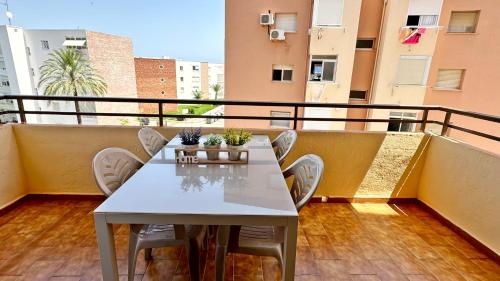 a white table and chairs on a balcony at LAS OLAS GANDIA - Alquiler solo a familias in Tarancón