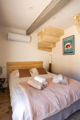 une chambre avec un grand lit avec des serviettes dessus dans l'établissement Mas provençal avec piscine chauffée !, à Tarascon