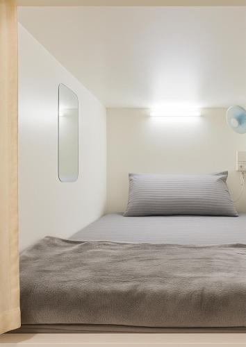 迪拜Goodwill Holidays ,Near Jumeirah Beach Residence 1的白色卧室内的一张床位,卧室内拥有白色的墙壁