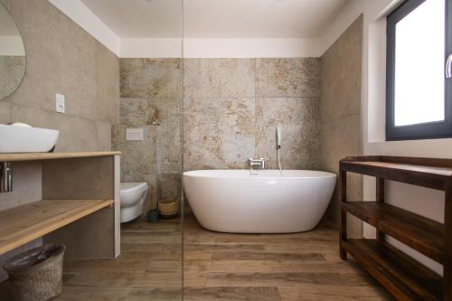 une salle de bain avec une baignoire blanche et des toilettes dans l'établissement Mas provençal avec piscine chauffée !, à Tarascon