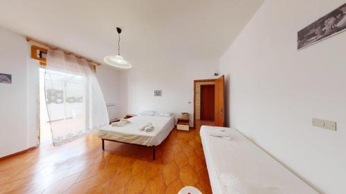 a white room with a bed and a large window at CIAK House in Maglie