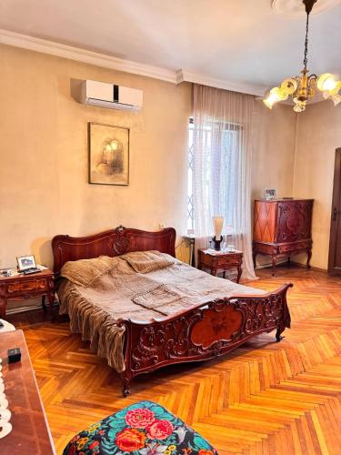 a bedroom with a large bed and wooden floors at Villa Kosmopoliten in K'obulet'i
