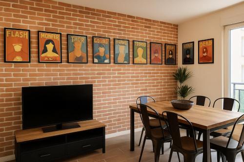 une salle à manger avec une table et une télévision ainsi qu'un mur en briques dans l'établissement ❀ Disneyland Paris, Résidence Privée dans Centre ❀, à Chessy