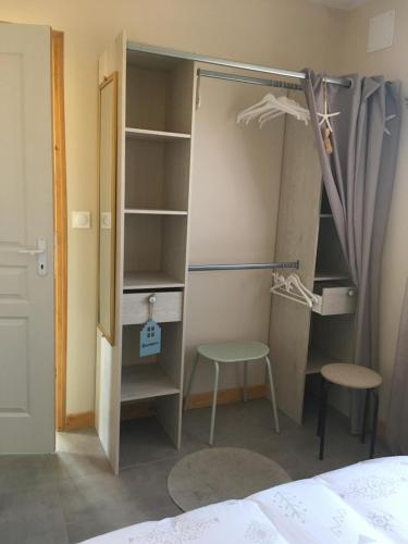 a room with a closet with a bed and a stool at Mon chalet in Le Teich