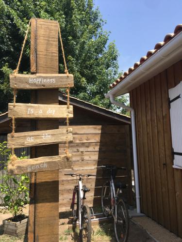 a bike parked next to a building with a sign that reads happiness at Mon chalet in Le Teich