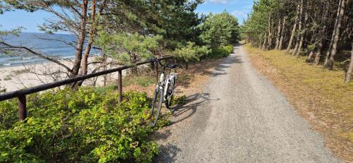 a bike parked on a dirt road next to a fence at Hotel White in Krynica Morska