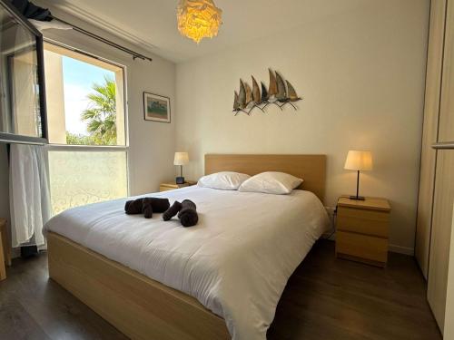 une chambre avec un lit avec deux ours en peluche dessus dans l'établissement Coquet pavillon avec jardin et terrasse dans une résidence à 500m de la mer, à Sérignan
