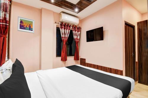 a hotel room with a bed and a tv at Super Collection O Park Circus in Kolkata