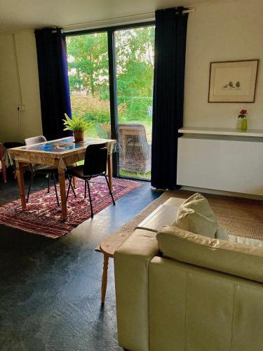 a living room with a couch and a table at Natuurhuis Marke Lemselo 80 m2 in Weerselo
