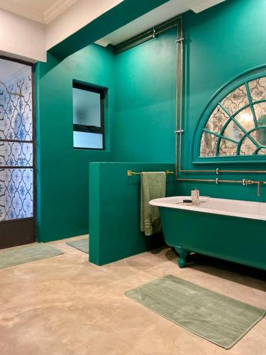 a green bathroom with a tub and a window at Underberg - The Burn - Solar Powered in Underberg