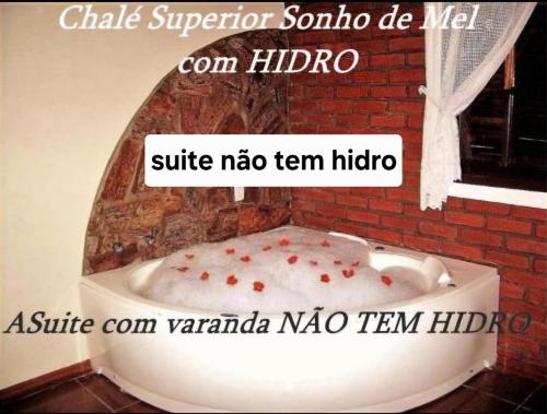 a bathroom with a bath tub with a window at Pousada Amor Perfeito in Visconde De Maua