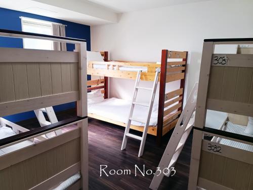 a room with two bunk beds and a ladder at Ace Inn Asakusa in Tokyo