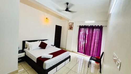 a bedroom with a bed and a pink window at Nestora Suites in Kozhikode