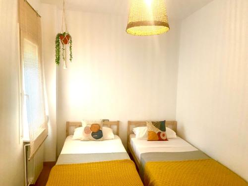 2 camas en una habitación pequeña con lámpara en Tucan tropical, en Sabadell