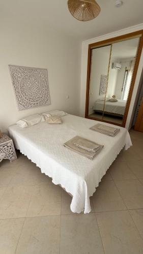 a bedroom with a large bed with a mirror at BS House Praia da Lota - Casa à Beira-Mar in Vila Nova De Cacela
