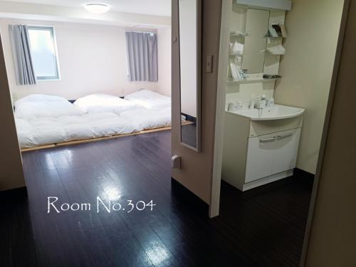 a room with two beds and a sink and a mirror at Ace Inn Asakusa in Tokyo