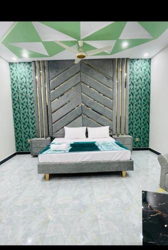 a bedroom with a bed with a large headboard at Ayan stay inn in Dargai